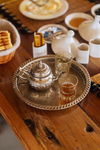 a tray with a tea kettle and two glasses on a table at Ô TALIA Hôtel and SPA in Nungwi