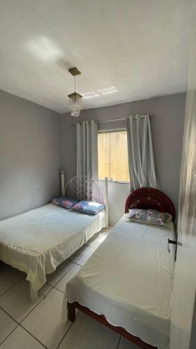 una camera da letto con due letti e una finestra di Sítio Carmo a Ibirité