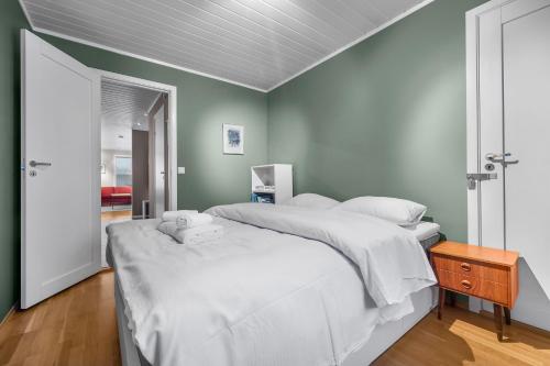 a bedroom with two beds with white sheets at Northstay - Tromsø Urban Escape, Modern House with 3 bedrooms, Free Parking in Tromsø