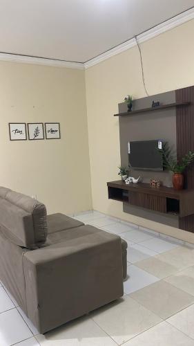 een woonkamer met een bank en een flatscreen-tv bij Casa Cariri Mobiliada com 2 Quartos e 2 Camas in Juazeiro do Norte