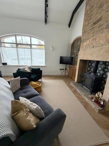 een woonkamer met een blauwe bank en een open haard bij The Reading Room, Shilbottle in Shilbottle