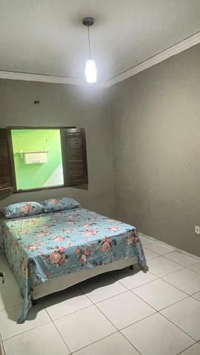 een slaapkamer met een bed en een televisie aan de muur bij Casa Cariri Mobiliada com 2 Quartos e 2 Camas in Juazeiro do Norte