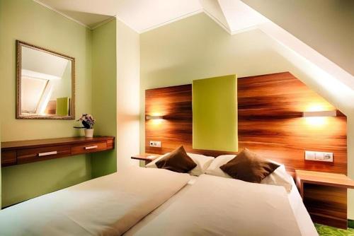 a bedroom with a large bed with a mirror at Ferenc Hotel Budapest in Budapest
