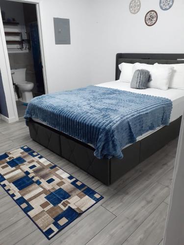 a bedroom with a bed with a blue blanket and a rug at Small's Cozy Rest 7 Efficiency in South Bimini