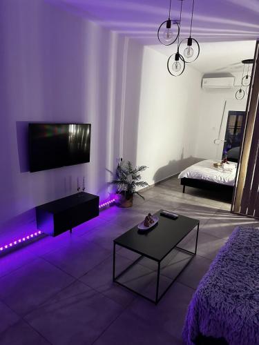 a living room with purple lights and a bed at Panthera-urban-studio in Xanthi