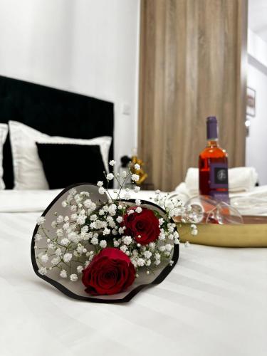 a bottle of wine and flowers on a bed at Panthera-urban-studio in Xanthi