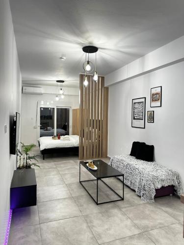 una sala de estar con una cama y una mesa en Panthera-urban-studio, en Xanthi
