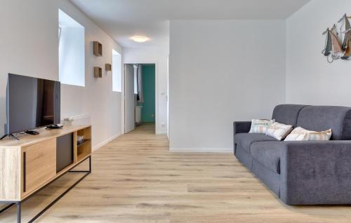 a living room with a couch and a tv at Gite Gouville Sur Mer in Gouville-sur-Mer