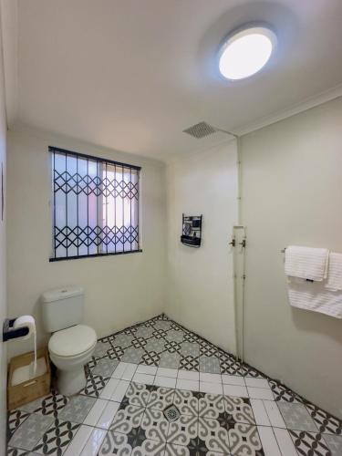 a bathroom with a toilet and a window at Ladybird in Durban