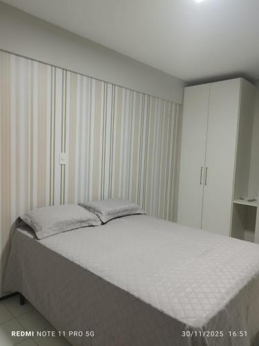 a bedroom with a large bed with white sheets at Flat Biarritz - Praia Litorânea in São Luís