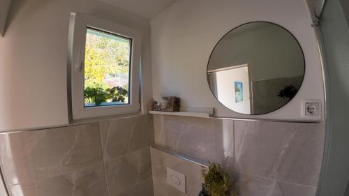 a bathroom with a mirror and a window at Holiday House with scenic Apartment in Ptuj