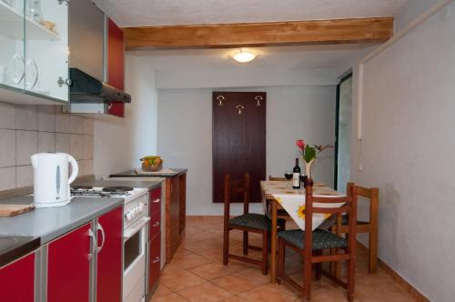a kitchen with a table and chairs and a table and a kitchen with a stove at Apartment Tomic A-5 in Lovran
