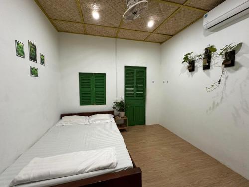 a bedroom with a bed and green shuttered windows at Homestay Dat Phu in Tuy Hoa