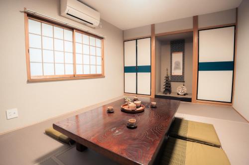 a living room with a wooden table and windows at HMV Horyuji in Ikaruga