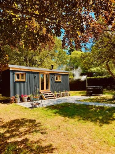a tiny house in a yard with a patio at Worcester Escape in Hallow
