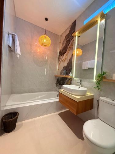 a bathroom with a sink and a tub and a toilet at Genta Villa Bali in Sanur