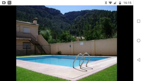 a picture of a swimming pool in front of a house at La Osera in Arroyo Frio