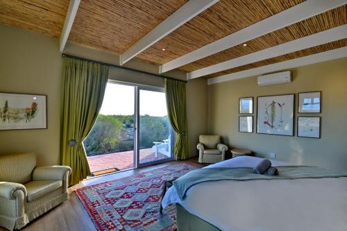 De Hoop Villa في De Hoop Nature Reserve: غرفة نوم بسرير كبير ونافذة كبيرة