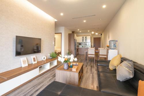 a living room with a couch and a television at Duc Hoang Residence & Hotel West Lake in Hanoi