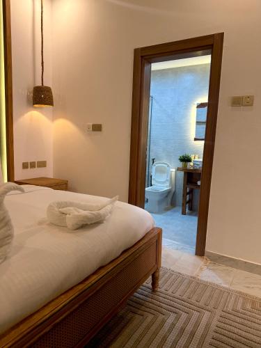 a bedroom with a bed and a bathroom with a toilet at Nomad Inn Tiwi Albir in Sur