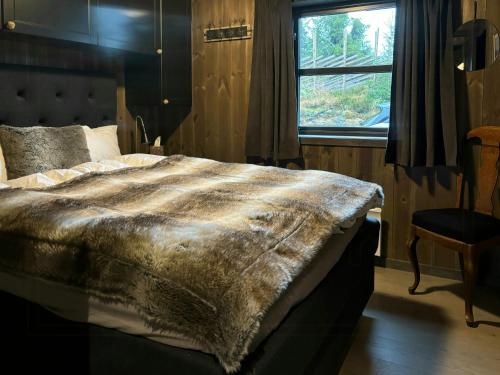 Un dormitorio con una cama con una manta encima. en Modern Cabin With Views Of Skeikampen, en Svingvoll