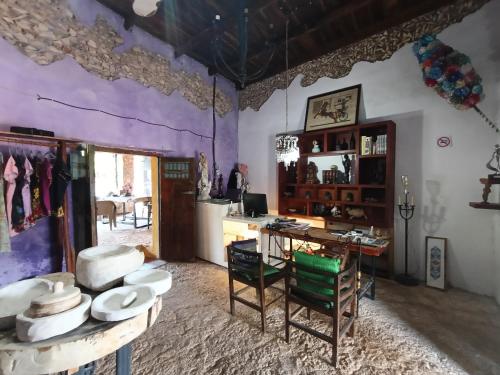 una stanza con una scrivania e un tavolo con cappelli di Hotel Tihosuco Colonial a Tihosuco