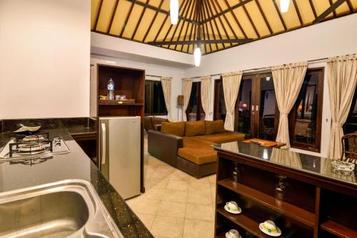 a kitchen and living room with a couch at Dolphin Beach Bali in Lovina
