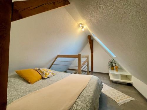 a bedroom with a bed and a stair case at Chez L en Alsace - Maison avec jardin et piscine spa proche d'Obernai in Griesheim-près-Molsheim