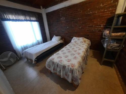 una camera da letto con un letto e un muro di mattoni di Dina Huapi a Las Grutas