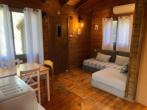 ein Wohnzimmer mit Sofa und Tisch in der Unterkunft בקתת היערן- בטבע פראי למשפחות ולזוגות in Merom Golan