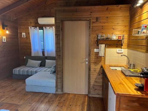 eine Küche mit einer Tür, die in ein Zimmer führt in der Unterkunft בקתת היערן- בטבע פראי למשפחות ולזוגות in Merom Golan