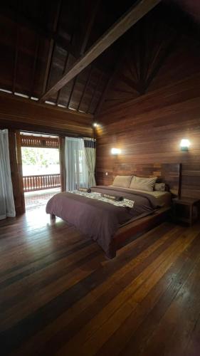 a bedroom with a bed in a wooden room at Villa D'La Madeira in Mantang
