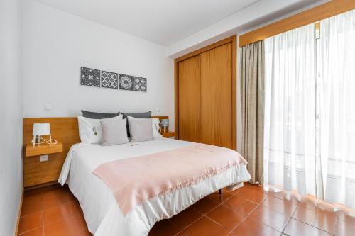 a bedroom with a bed and a large window at Gerês Cascatas Residence in Geres