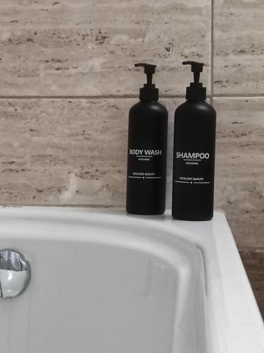 two black bottles sitting on top of a sink at 3 Mountains Luxury House in Aridaia