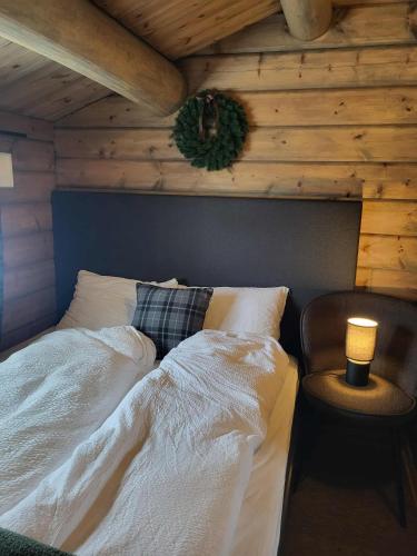 a bed in a room with a wooden wall at Bjorlicabin in Bjorli