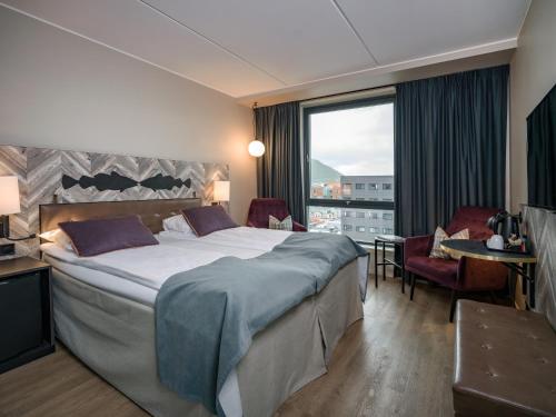 a hotel room with a large bed and a large window at Quality Hotel Grand Tromsø in Tromsø