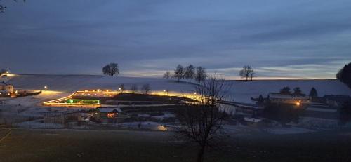 Blick auf eine Stadt im Schnee in der Nacht in der Unterkunft Modularhouses Nochilinga in Nöchling