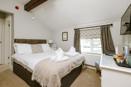 a bedroom with a bed with towels on it at The Sun Inn At Hook Norton in Banbury