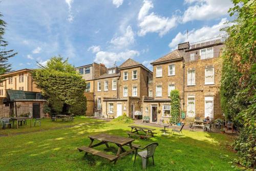 a park with benches and tables in front of a building at Amhurst Hotel in London