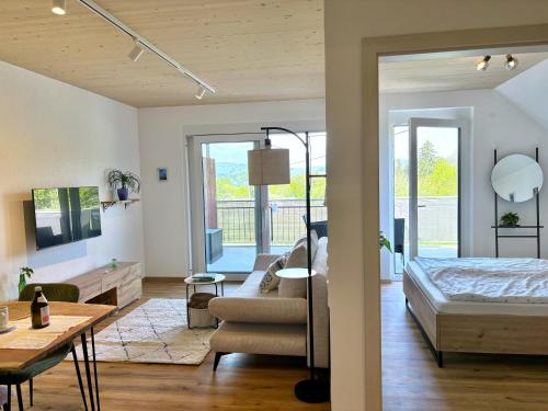 a bedroom and living room with a bed and a couch at Ferien am Winkelhof in Deggenhausertal