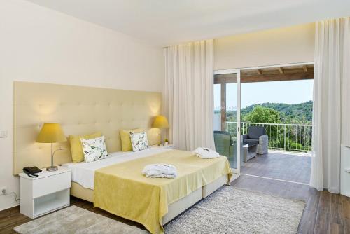 塔维拉Hotel Rural Quinta do Marco - Nature & Dining的一间带大床的卧室和一个阳台