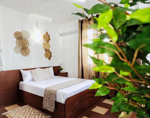 Vintage 90s Port Louis apart near Jeetoo Hospital في بورت لويس: غرفة نوم بسرير في غرفة بها نباتات