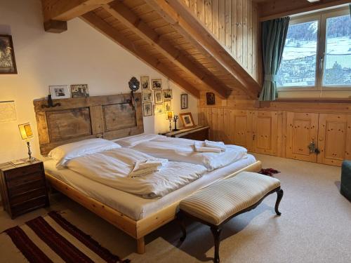 Un dormitorio con una cama grande con cabecero de madera. en Chesa Principela - La Punt, en La Punt-Chamues-ch