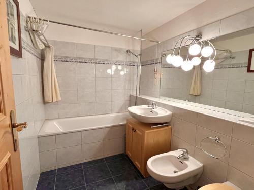 Un baño con lavabo, inodoro y espejo. en Chesa Principela - La Punt, en La Punt-Chamues-ch