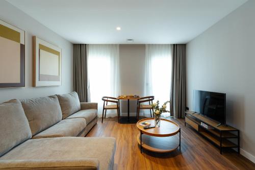 una sala de estar con un sofá y una mesa en Apartamentos 2H LIVING, en León