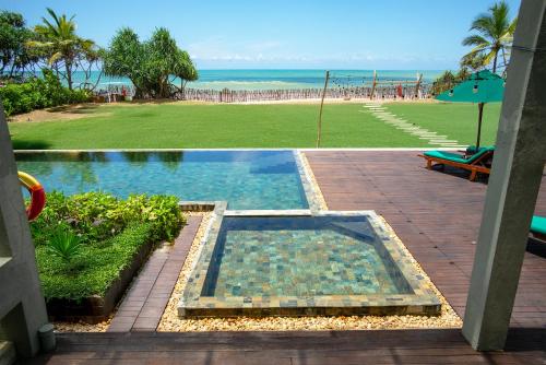 a view of a swimming pool and a beach at Six Elements Beach Villa in Tangalle