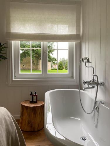 a white bath tub in a bathroom with a window at Ragnar Glamp Koknese Forest in Koknese