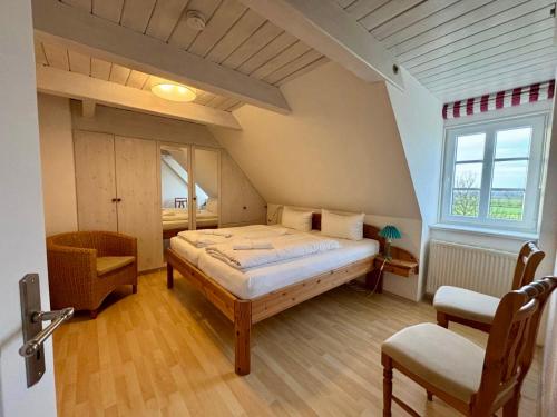 a bedroom with a large bed in a attic at Adlerhorst - Moderne 60 qm Wohnung mit Terrasse in Oevenum