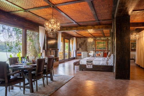 Debre ZeyitKuriftu Resort & Spa Bishoftu的一间卧室，里面有一张床、一张桌子和几把椅子。