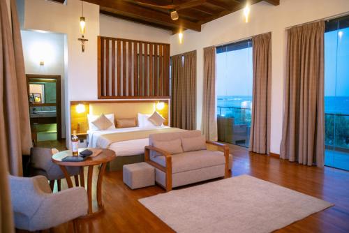 a hotel room with a bed and a table and chairs at Six Elements Beach Villa in Tangalle